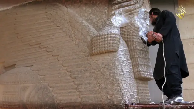 Bức hình cho thấy một dân quân IS đang khoan phá tượng Lamassu