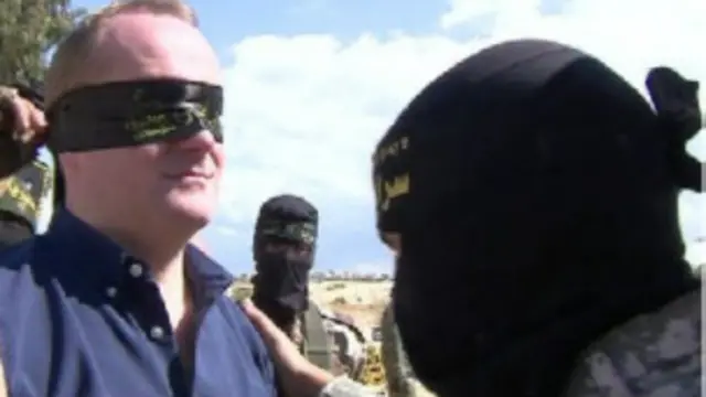 عصب المسلحون عيني كوينتين سومرفيل، قبل اصطحابه إلى النفق