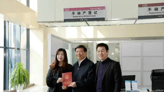 3月1日，在江蘇徐州市不動產登記交易服務中心，國土資源部部長姜大明（中）為徐州市民頒發不動產權證書。