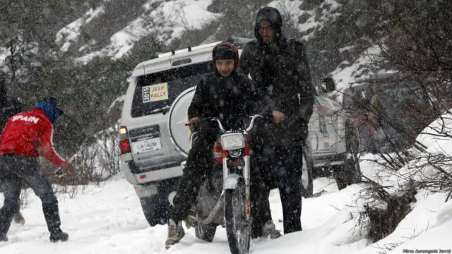 ایک موٹرسائیکل سوار جیپ ریلی کے راستے میں برف کی وجہ سے پھنسا ہوا ہے۔