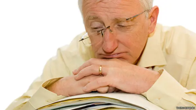 Señor mayor sobre una pila de papeles