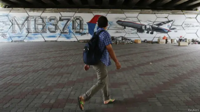 Мужчина на фоне граффити MH370