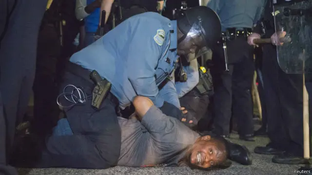 Polisi menangkap salah seorang pemrotes yang menuntut tindak lanjut laporan federal tentang bias rasial di kepolisian kota Ferguson