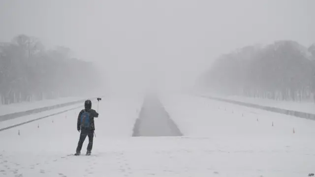 Di tengah salju yang tebal di Washington DC, pria ini menyempatkan diri memakai tongsisnya.