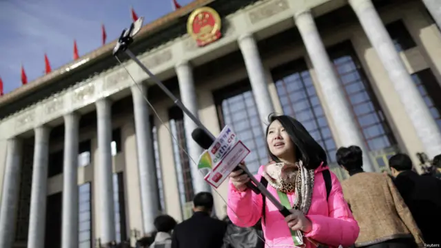 Wartawati ini juga menggunakan tongsis saat meliput Kongres Rakyat Nasional Cina di Beijing.