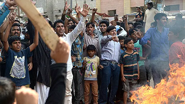 تصاویر میں لوگوں کو دو مشتبہ شدت پسندوں کو جلاتے ہوئے دیکھا جا سکتا ہے