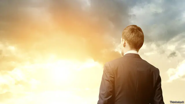 Мужчина смотрит на восходящее солнце