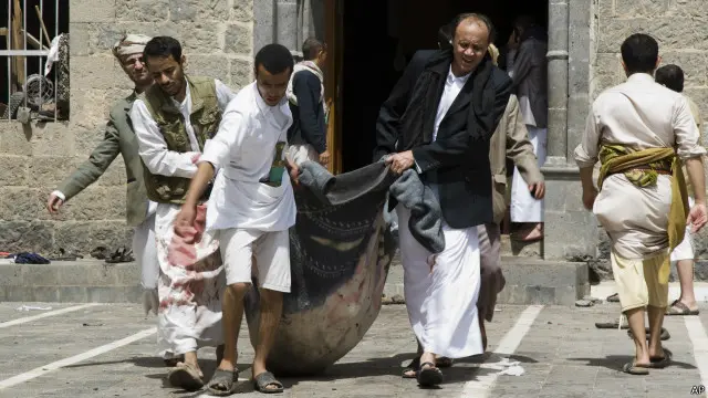 يمنيون يحملون أشلاء قتلى سقطوا في الهجمات. 