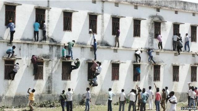 Gente escalando las paredes de un colegio