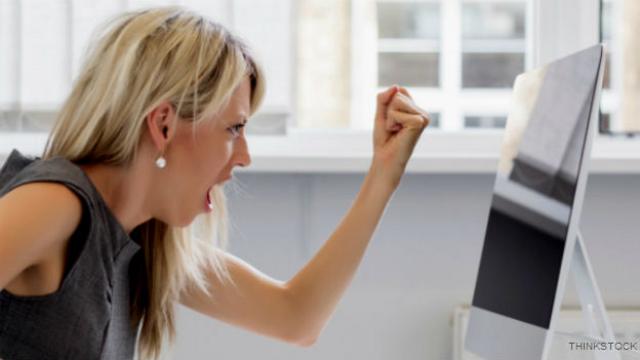 Una empleada se pelea con la pantalla de su computadora