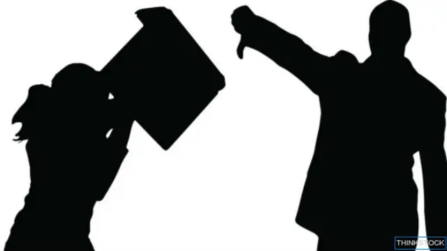 Siluetas de dos empleados peleando computadora en mano