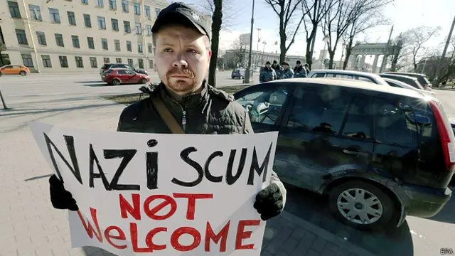 Учасник пікету з плакатом "Нацистському бруду тут не раді"
