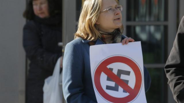 Российская антифашистка держит плакат во время акции протеста против проведения в Санкт-Петербурге форума европейских наионалистов и правых (22 март 2015 г.)
