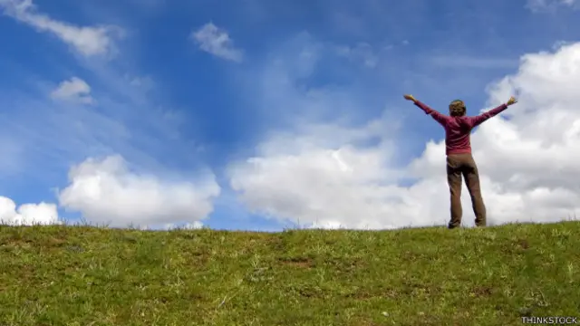 Una persona en un campo con los brazos extendidos