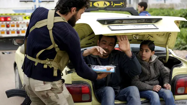 یکی از شبهنظامیان در میان کسانی که از ترس بمباران از ادلب فرار میکنند، شکلات پخش میکند