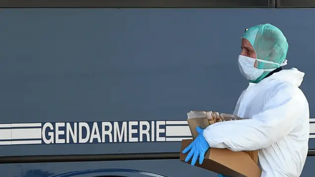 Bir polis yolculardan alınan DNA örneklerini olay yerine kurulan bir laboratuvara taşıyor. 