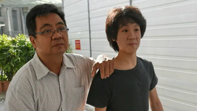 Amos Yee datang ke pengadilan ditemani ayahnya.