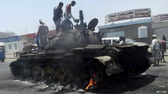 مردم غیرنظامی در عدن سوار بر تانکی که در نبردها منهدم شده
