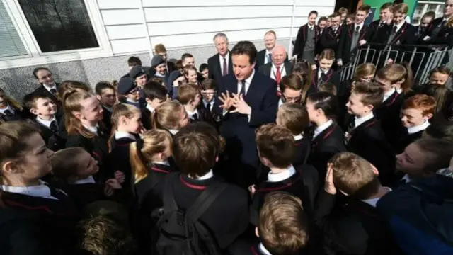 英国首相卡梅伦在一所小学和学生见面，开玩笑的说要在晚上的电视辩论中把英国独立党领导人压倒在地。