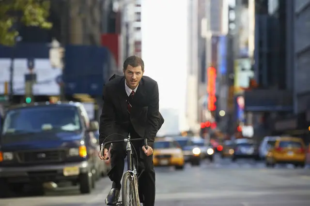 Мужчина в костюме на велосипеде