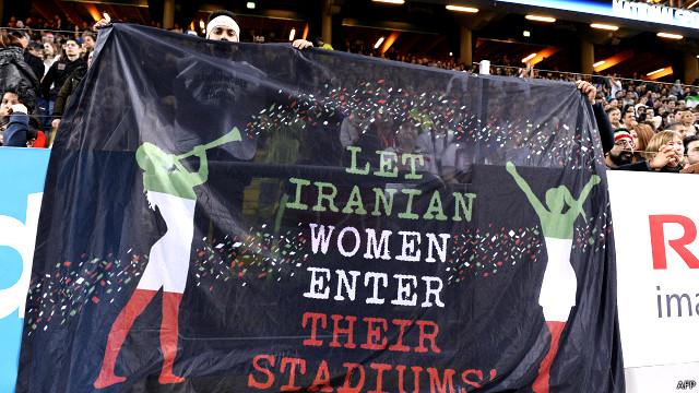 مسابقه فوتبال دوستانه ایران و سوئد در استکهلم. روی پارچه نوشته شده "بگذارید زنان ایرانی وارد استادیوم شوند"