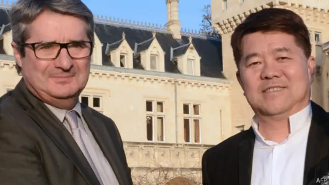 郝琳(右)买下酒庄时与其前主人握手