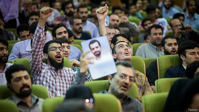 عکس مصطفی احمدی روشن، از دست اندرکاران برنامه هسته‌ای ایران که مورد سوءقصد قرار گرفت، در دست یکی از شرکت کنندگان در جلسه 'دلواپسیم' 