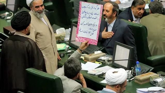 مهدی کوچکزاده نماینده منتقد دولت پلاکاردی را در مخالفت با تفاهم لوزان به دست گرفته است