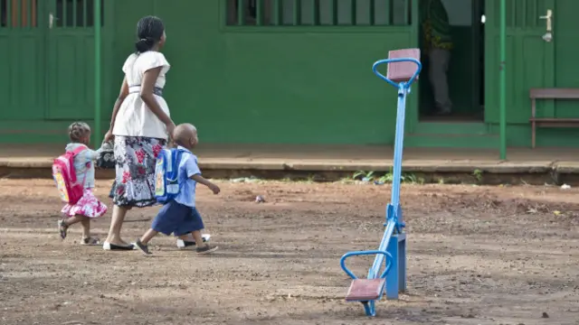 Madre llevando a niños a la escuela