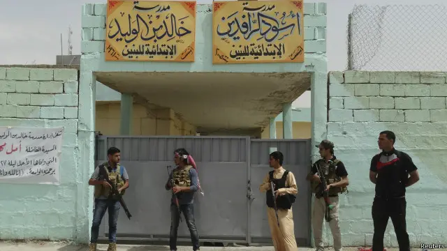 مسلحون من قبائل سنية يحرسون مدرسة تحولت إلى ملجأ لإيواء النازحين في الرمادي.