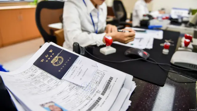 深圳福田公安分局行政職員處理港澳通行簽注申請(新華社圖片13/4/2015)