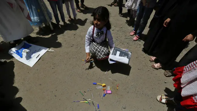 طفلة يمنية وقد دمرت مدرستها في القصف السعودي