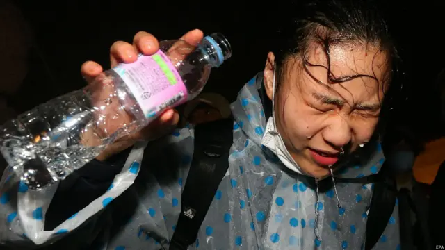 韓國首爾光化門外一名被胡椒噴劑噴到的示威者用清水衝洗眼睛（18/4/2015）
