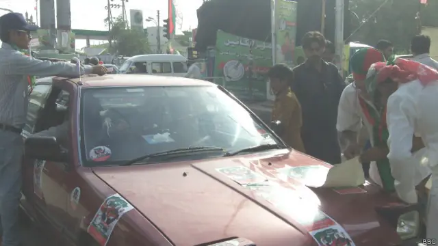 تحریک انصاف کے نو عمر لڑکے الیکشن کیمپ کے پاس رکنے والی ہر گاڑی پر تحریک انصاف کے اسٹیکر چپساں کردیتے ہیں