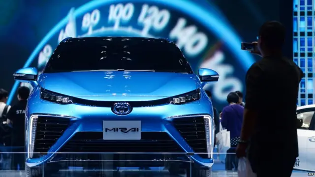 A man takes a photo in front of a Toyota Mirai during the 16th Shanghai International Automobile Industry Exhibition in Shanghai on April 22, 2015.