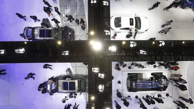 Visitors and cars are seen reflected on ceiling mirrors at the Buick booth at the 16th Shanghai International Automobile Industry Exhibition in Shanghai, China, 22 April 2015.