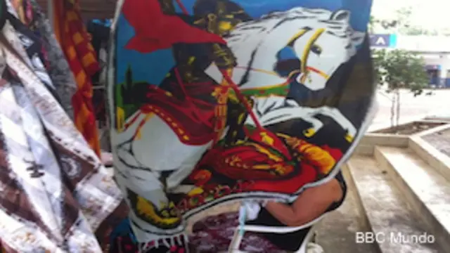 Vendedora cubierta por una toalla con la figura de San Jorge en una calle de Río.