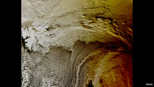 O satélite TERRA, da NASA, registrou a sombra do eclipse solar sobre as nuvens do Oceano Ártico. (Crédito: NASA)