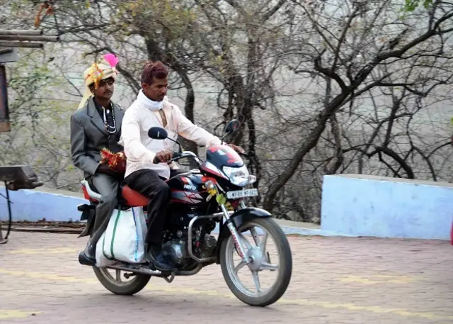 बाइक पर सवार दुल्हा मंदिर जाते हुए.