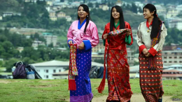 طالبات مدارس بأزياء شعبية بوتانية أمام تمثال "بوذا دوردينما" في "تيمفو"