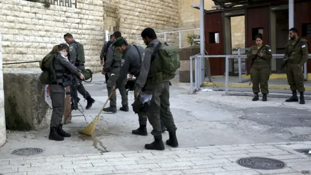 الجنود الاسرائيليون يزيلون آثار الدم من مكان الحادث