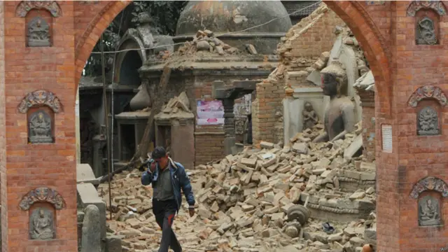 اتوار کو ملبے سے باہر آتا ہو ایک شخص اپنے جذبات پر قابو نہ رکھ سکا۔ عقب میں تباہ مندر نظر آ رہا ہے۔