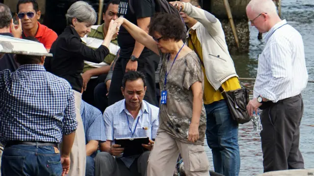 印尼芝拉扎港口安德魯•陳母親海倫（中）在澳大利亞駐巴厘總領事攙扶下登船前往努薩安邦島監獄（26/4/2015）