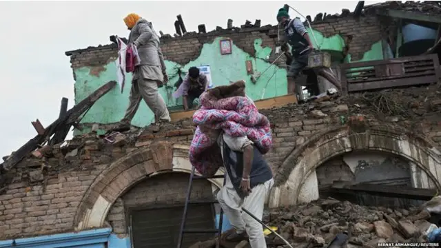 Katmandulular hasar gören binalardan kurtarabildikleri eşyalarını toplamaya çalışıyor.b 