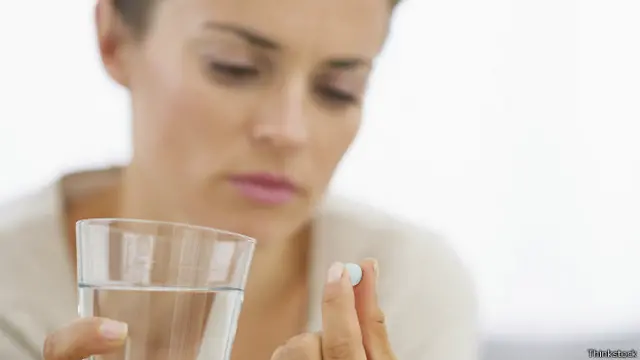 женщина с таблеткой в руке