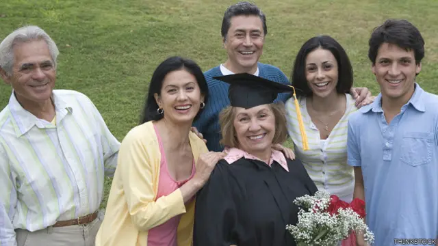 Una graduanda de edad madura junto a su familia