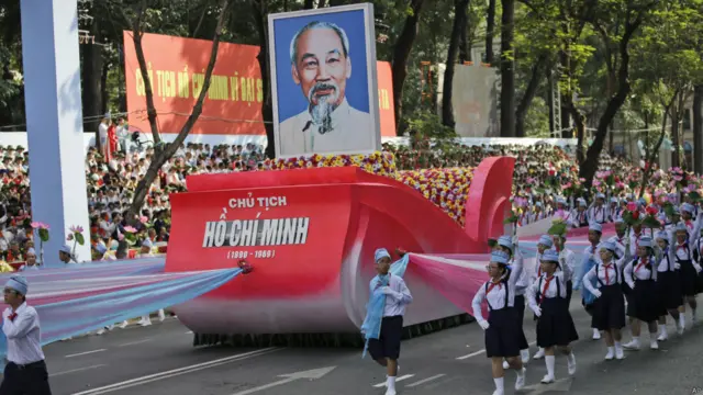 Các học sinh trung học diễu hành cùng chân dung của Chủ tịch Hồ Chí Minh