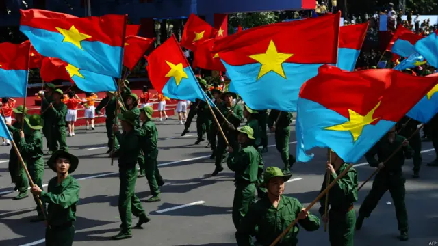 胡志明市阅兵式上学生挥舞原南越“越南南方民族解放阵线”旗帜（30/4/2015）