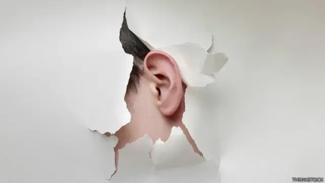 Oído saliendo de una pantalla de pared