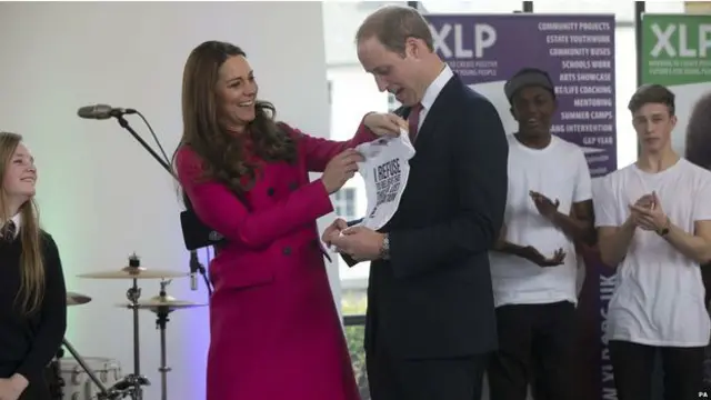 英国剑桥公爵夫妇在参观伦敦南部一个慈善机构时，获赠一套婴儿T恤衫。